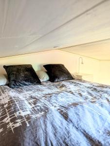 a bed with two pillows on top of it at Tiny house accommodation in Frillesås! in Frillesås