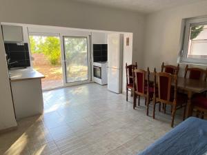 a kitchen and dining room with a table and a table and chairs at Pink Holiday House Sutomore in Zankovići