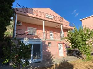 a pink house with a balcony on top of it at Pink Holiday House Sutomore in Zankovići