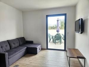 a living room with a couch and a table at Maison La p'tite des Got - Terrasse & Parking in Viriat