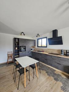 a kitchen with a table and chairs in a room at Maison La p'tite des Got - Terrasse & Parking in Viriat