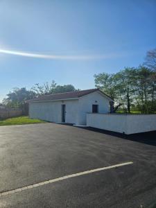 a large white building with a parking lot at Maison La p'tite des Got - Terrasse & Parking in Viriat