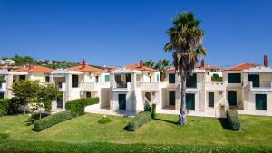 an exterior view of a villa with a palm tree at Hemera House Posidi H3 in Possidi