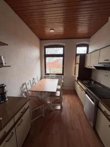 a kitchen with a table and chairs in a room at Emmerstedt - Alte Schule in Helmstedt