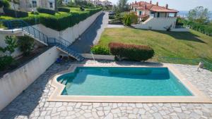 a swimming pool in a yard next to a house at Hemera House Posidi H3 in Possidi