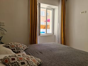 a bedroom with a bed and a window at AURA Apartments Novalja in Novalja