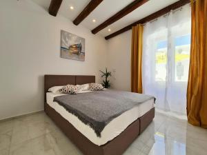 a bedroom with a large bed and a window at AURA Apartments Novalja in Novalja