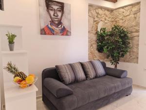a living room with a couch and a portrait of a man at AURA Apartments Novalja in Novalja