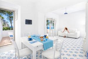 a white living room with a table and chairs at Casa Schiattarella Capri in Capri