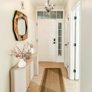 a hallway with a mirror and a table with flowers at Spacious Private 2BR-2BA I Pool I Garage I Central in Rehoboth Beach