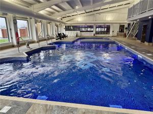 a large pool with blue water in a building at 7 Park Lane Patrington Haven Leisure Park in Patrington