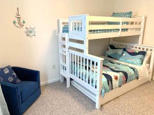 a white bunk bed and a blue chair in a room at Beach perfect getaway 2 bedroom apartment in Rehoboth Beach
