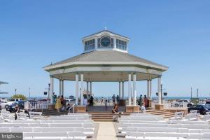 a gazebo with white chairs and people in it at Beach perfect getaway 2 bedroom apartment in Rehoboth Beach