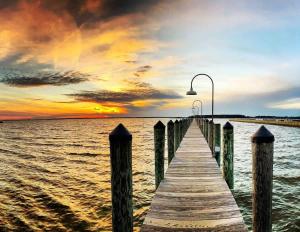 a wooden pier with a street light on the water at Beach perfect getaway 2 bedroom apartment in Rehoboth Beach