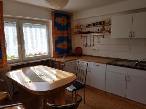 a kitchen with white cabinets and a wooden table at Monteurswohnung am Obstgarten in Klingenberg