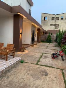 a motorcycle parked in the courtyard of a house at Hôtel Okpèyèmi in Porto-Novo