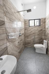 a bathroom with a toilet and a sink at Varkalite homestay in Varkala