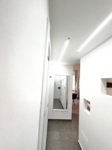 a hallway with white walls and a mirror at Cavour 16 Biella Studio Centro in Biella