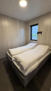 a large bed in a room with a window at Tommutún cottages in Borgarnes