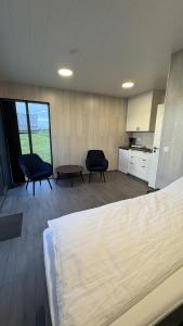 a room with two chairs and a bed and a kitchen at Tommutún cottages in Borgarnes