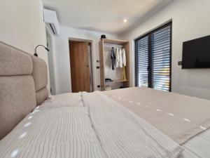 a bedroom with a large bed and a flat screen tv at Villa Atma in Murine +42 photos