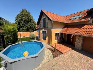 a swimming pool in the backyard of a house at Vianelli apartman in Zamárdi
