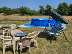 a group of tables and chairs with a slide in front of a pool at Konak Kragujevac in Kragujevac