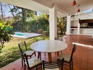 a patio with a table and chairs and a pool at Estancia Bogotá in Ciudad Lujan de Cuyo