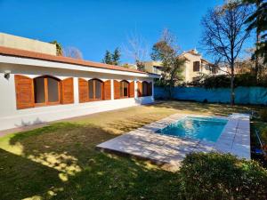 a house with a swimming pool in the yard at Estancia Bogotá in Ciudad Lujan de Cuyo