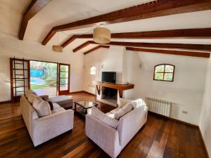 a living room with two couches and a fireplace at Estancia Bogotá in Ciudad Lujan de Cuyo