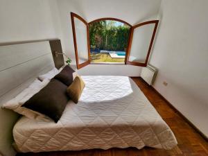 a bedroom with a large bed with a window at Estancia Bogotá in Ciudad Lujan de Cuyo +32 photos