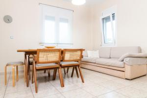 a living room with a couch and a table and chairs at Dimeli 1 in Plaka Litochorou