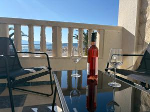 a bottle of wine sitting on a table with two wine glasses at Apartmány Júlia in Živogošće
