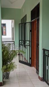 an empty hallway with a wooden door and plants at AvocadoAirbnb in Arusha
