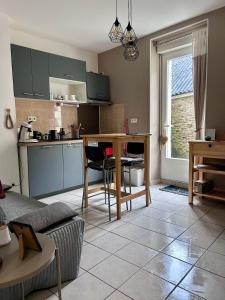 a living room with a table and a kitchen at Le Petit Cocon de Pleyben in Pleyben