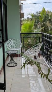 a balcony with two chairs and a table at AvocadoAirbnb in Arusha