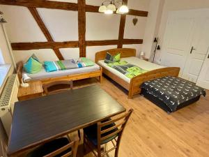 a small room with two beds and a table at Ferienwohnung "Ankerplatz" mit 2 Schlafzimmern in Rheinsberg