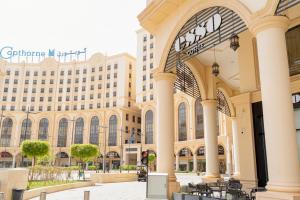 a large building with tables and chairs in front of it at Millennium Makkah Al Naseem in Mecca