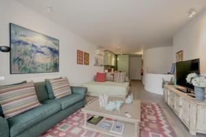 a living room with a couch and a tv at Quinta do Lago Duplex - Beach & Golf Algarve in Loulé
