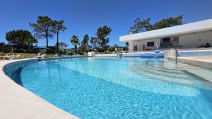 a large blue swimming pool in front of a building at Quinta do Lago Duplex - Beach & Golf Algarve in Loulé