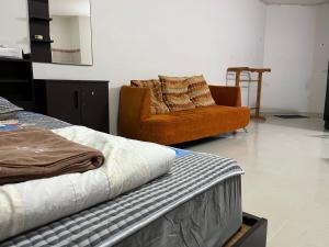 a living room with a bed and a chair at Impact Arena C5 by Jintana in Thung Si Kan