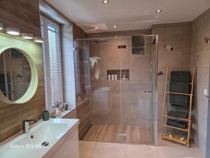 a bathroom with a shower with a tub and a sink at Appartement de Charme in Bévilard