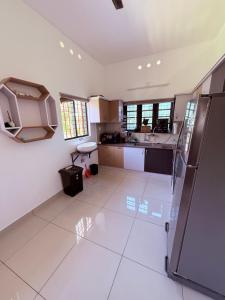 a large kitchen with white tile flooring at Luxury Villa Ps5 Home-Theater Hookah 30km 2 Munnar in Chillithodu