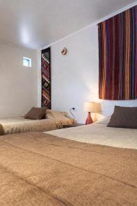 a hotel room with two beds and a window at Chill Atacama in San Pedro de Atacama