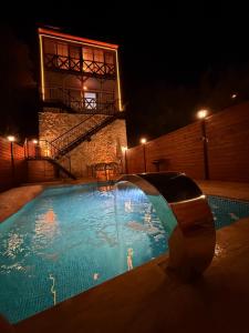 a swimming pool at night with people in the water at Doğayla İç içe Lüks Villa in İznik
