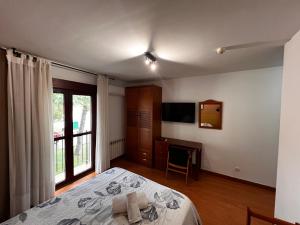 a bedroom with a bed and a desk and a television at Hotel Puente de Piedra in Zamora