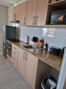 a kitchen with a sink and a refrigerator at Blouberg Guest suite, 3 km to the beach, Wi-Fi inc in Parklands
