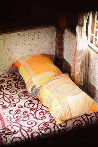 a bed with a pillow next to a window at Swindo Homestay 77, Small House in Berastagi