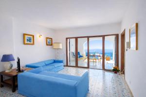 a living room with a blue couch and a table at Casa Gianna New 2026 in Praiano +19 photos