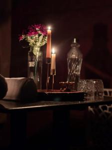 a table with a candle and a vase with flowers at Hidden Roots Sakleshpur in Hanbalu